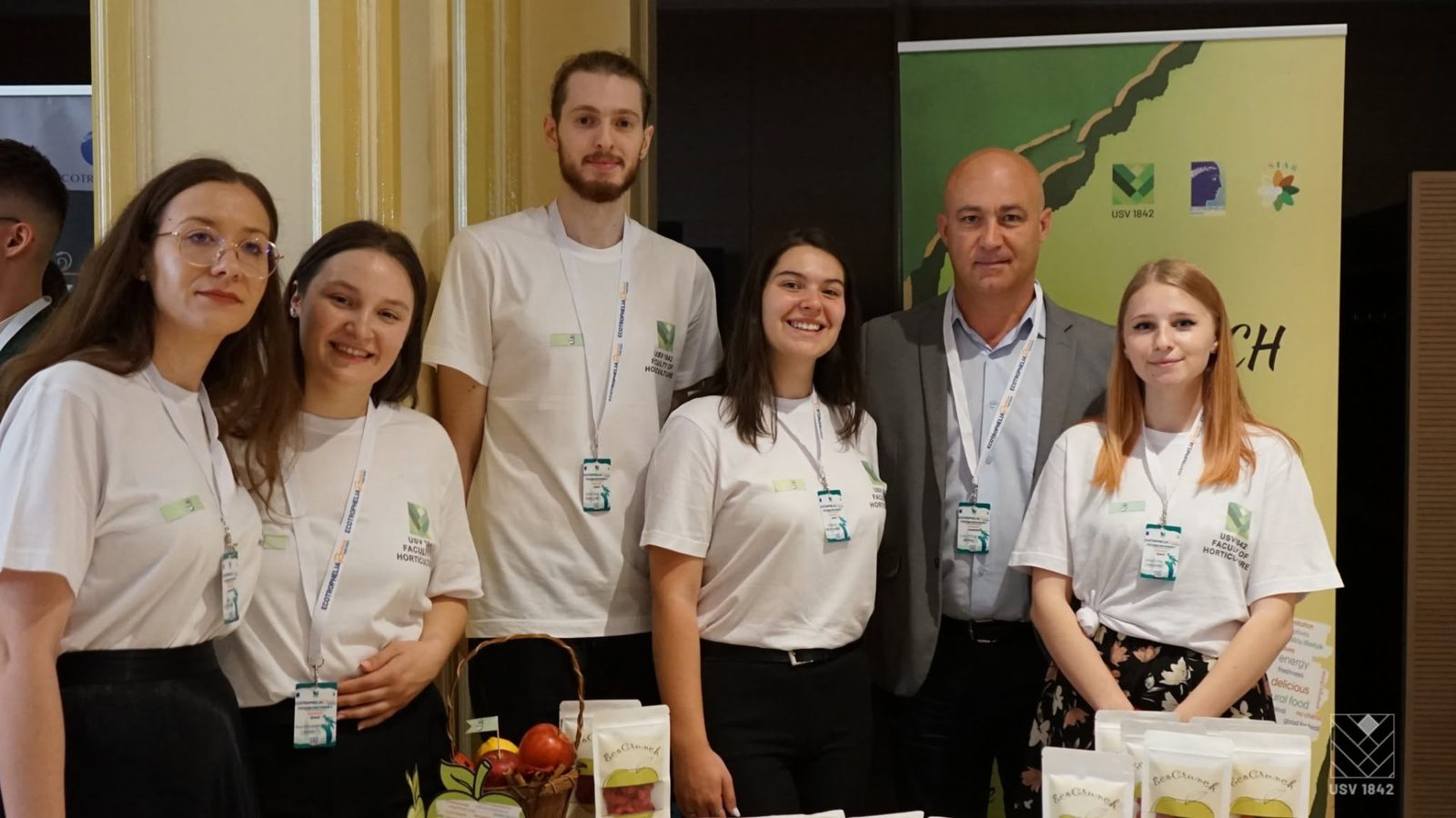 Echipa EcoCrunch, alături de un coordonator, la standul cu fructe deshidratate