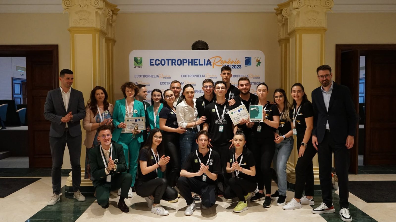 Fotografie de grup a echipelor premiate, în fața panoului oficial