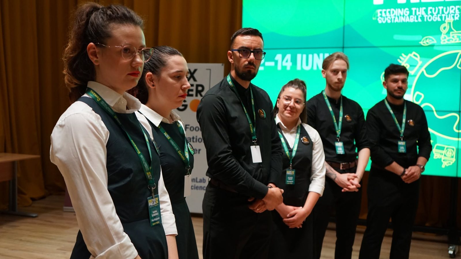 Echipă de studenți în fața ecranului cu identitatea vizuală a ediției, 12–14 iunie