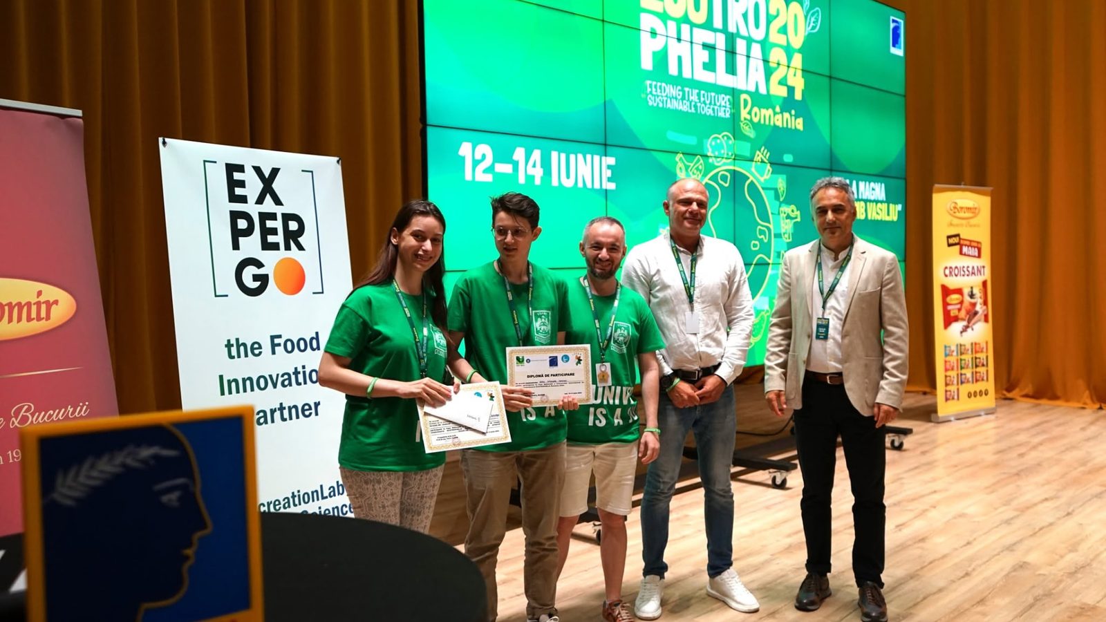 Echipă de studenți primind diploma de participare la festivitatea de premiere